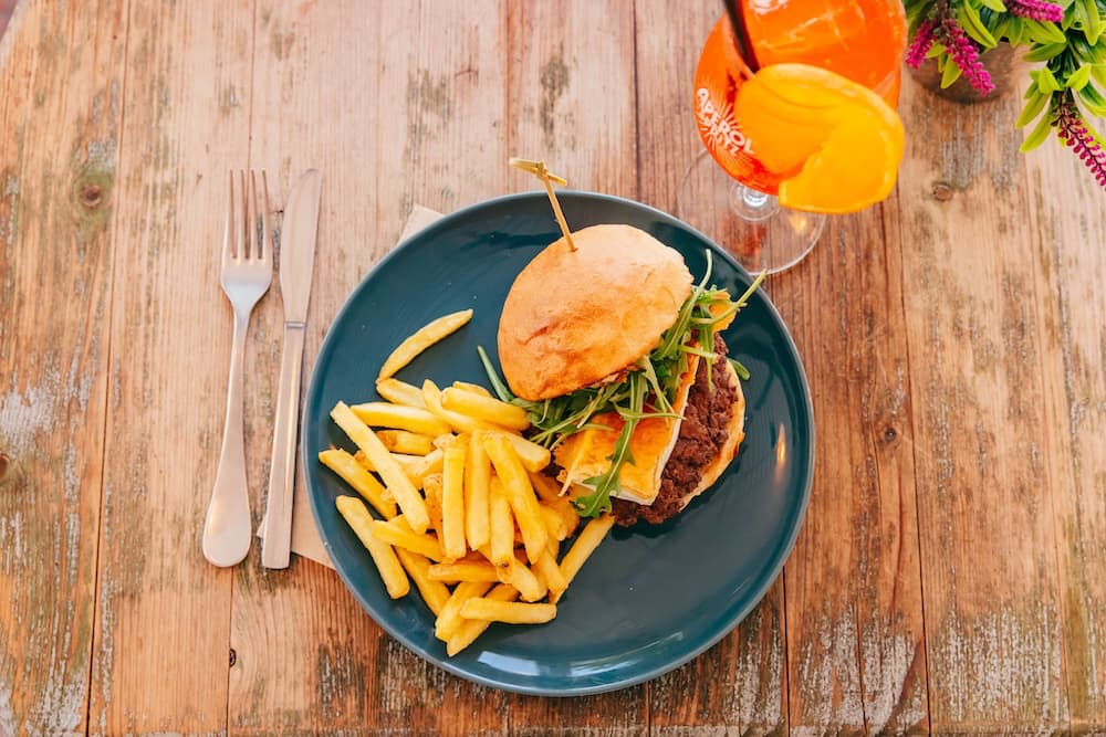 Burger and fries served with an orange drink