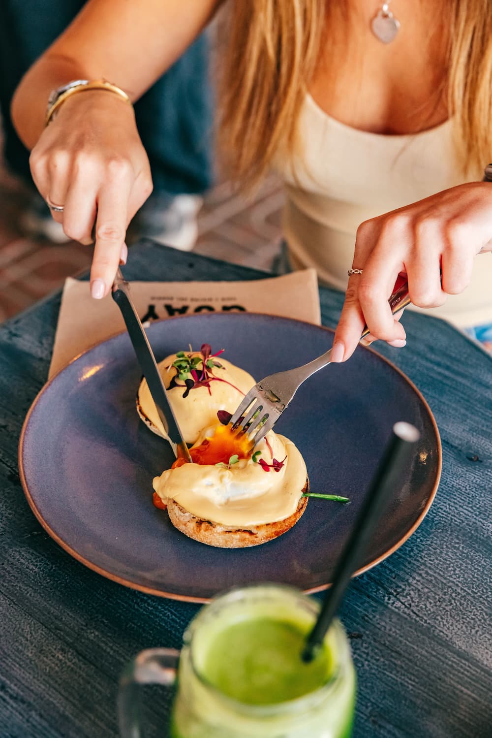 Guest cutting into an egg-topped breakfast