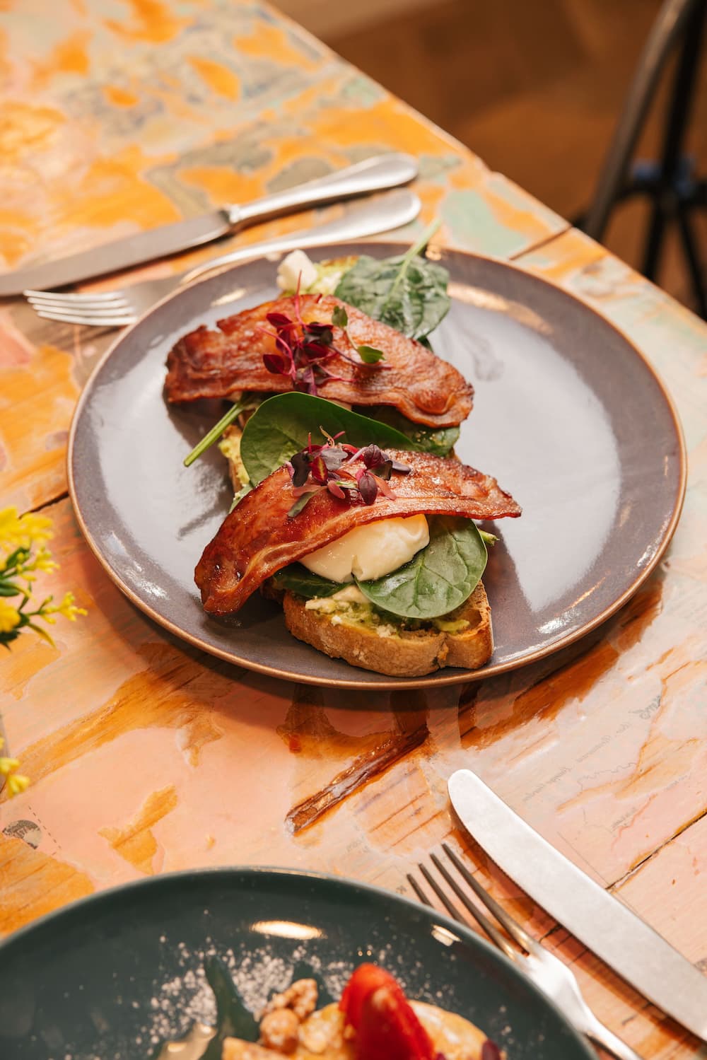 Poached eggs and bacon on avocado toast