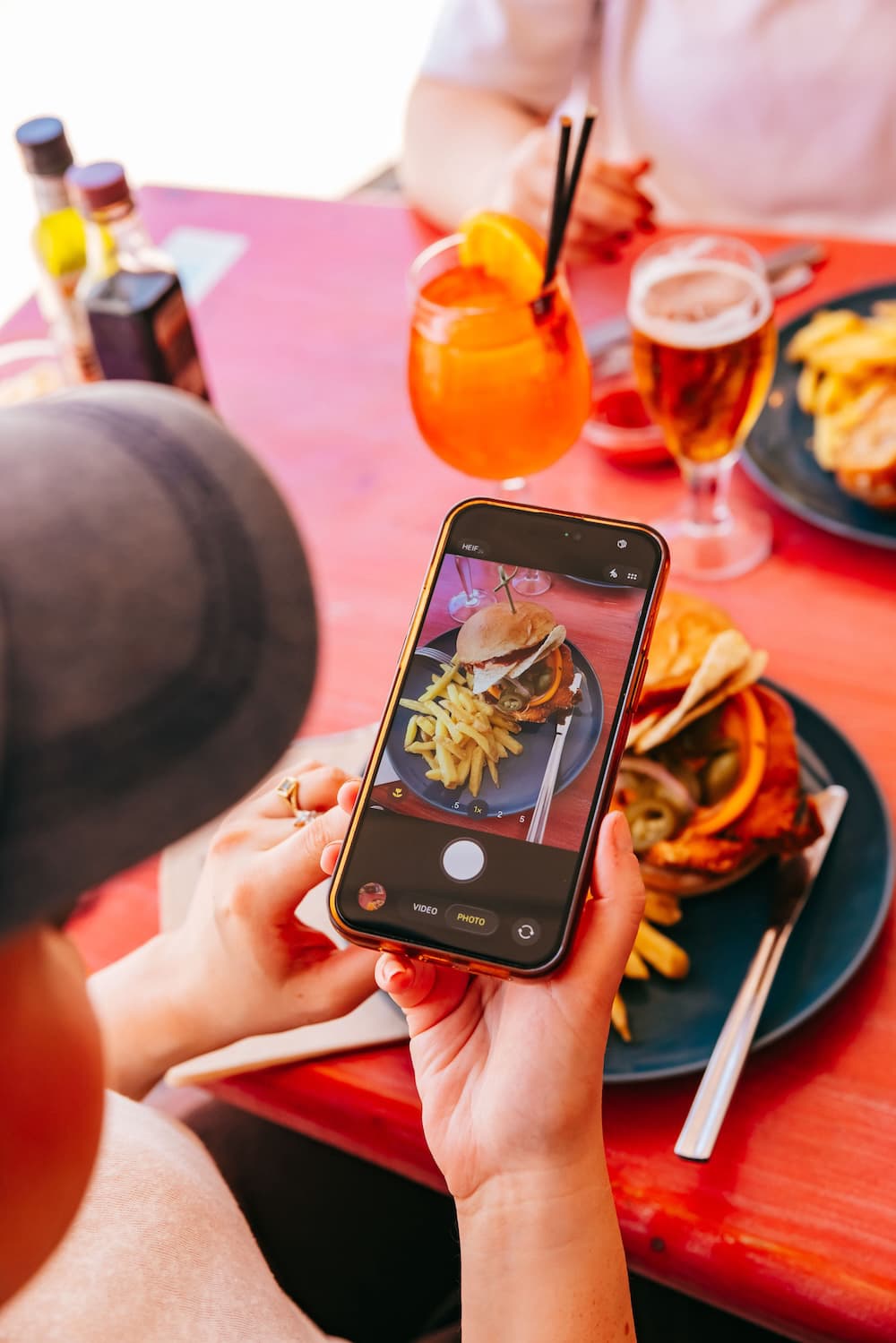 Guest photographing a burger and drinks